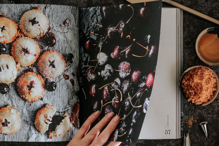 hand turning the page of a pastry cookbook
